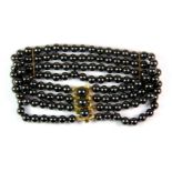 A 9ct yellow gold (stamped 9ct) and haematite bead bracelet.