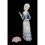 A Lladro figure of a girl with a parasol, H. 32cm.