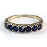A white metal (tested minimum 9ct white gold) sapphire set half eternity ring (S).