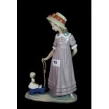 A Lladro figure of a girl pulling a cart, H. 28cm.