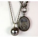 A hallmarked silver photograph locket on a sterling silver chain together with a white metal (tested