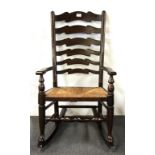 A rush seated and ladder backed rocking chair.