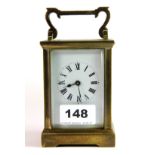 A 19th century brass and four glass carriage clock, with shaped swing handle, raised on four bracket