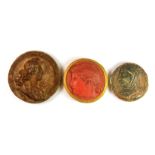 A group of three painted plaster roundels, each decorated with the head and shoulders portrait