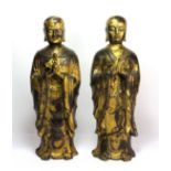 A pair of Tibetan gilt bronze figures of standing monks, H. 31cm.