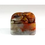 A lovely mixed colour carved hardstone mounted with a winged mythical creature, 4cm x 4cm x 3.2cm.