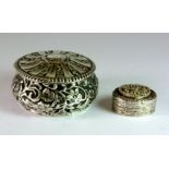 A late Victorian hallmarked silver circular lidded trinket box, embossed with floral decoration,