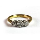 An 18ct yellow gold and platinum (stamped 18ct & plat) three diamond ring (K).