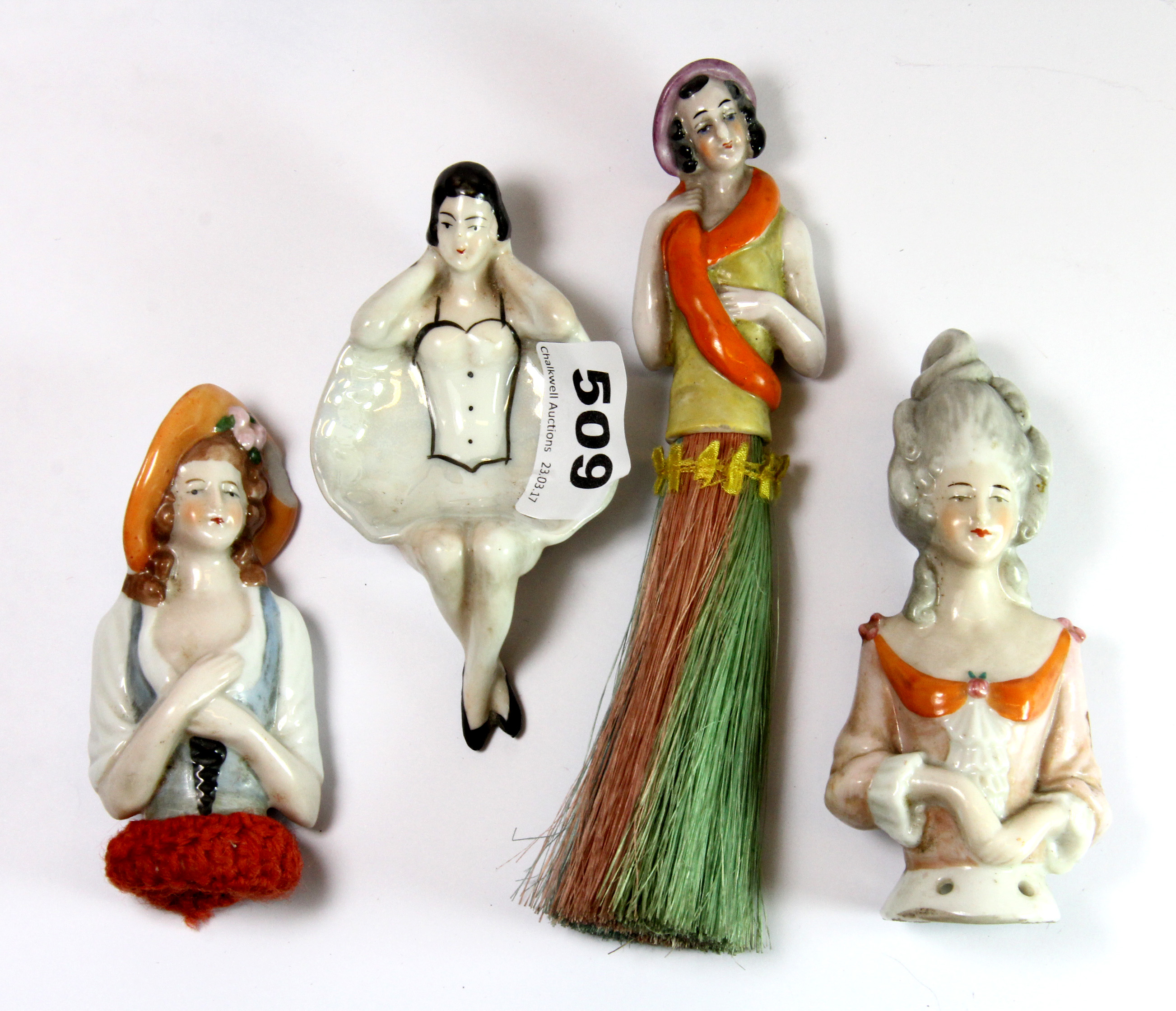 Three porcelain half dolls and a porcelain novelty ashtray.