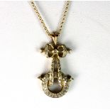 A yellow metal (tested minimum 9ct gold) diamond set bow pendant on a 9ct gold chain, L. 3.2cm.