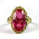 A 14ct yellow gold ring (stamped 585) set with an oval cut pink topaz (R).