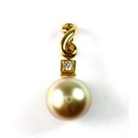 An 18ct yellow gold (stamped 750) pendant set with a natural cream pearl and a diamond, L. 2.7cm.