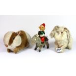 A vintage tin plate mechanical toy of a gnome riding a donkey, with a Merrythought rabbit and a