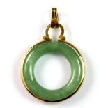 A yellow metal mounted polished jade pendant, Dia. 2.2cm.