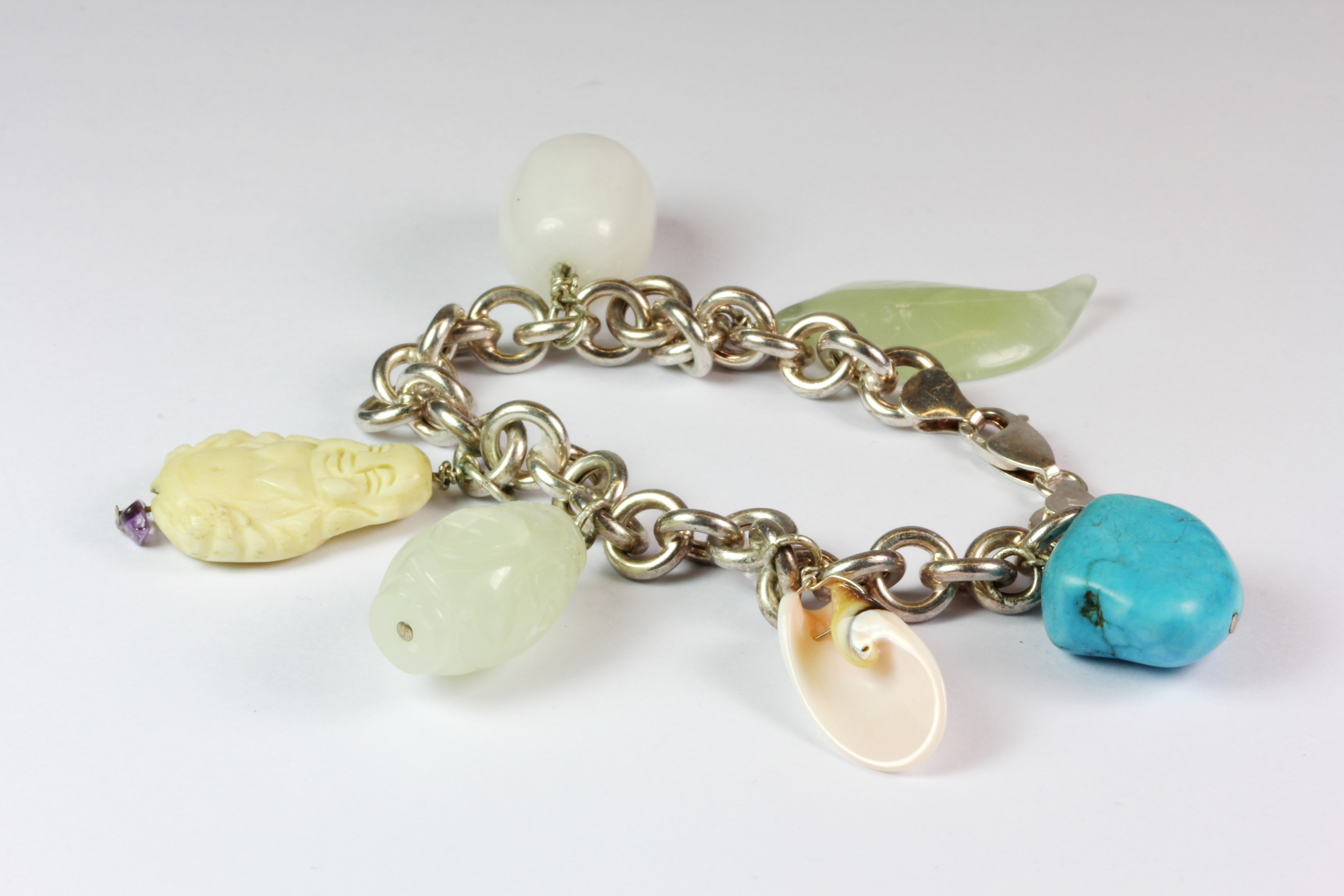 A 925 silver charm bracelet with carved jade and other stone charms.