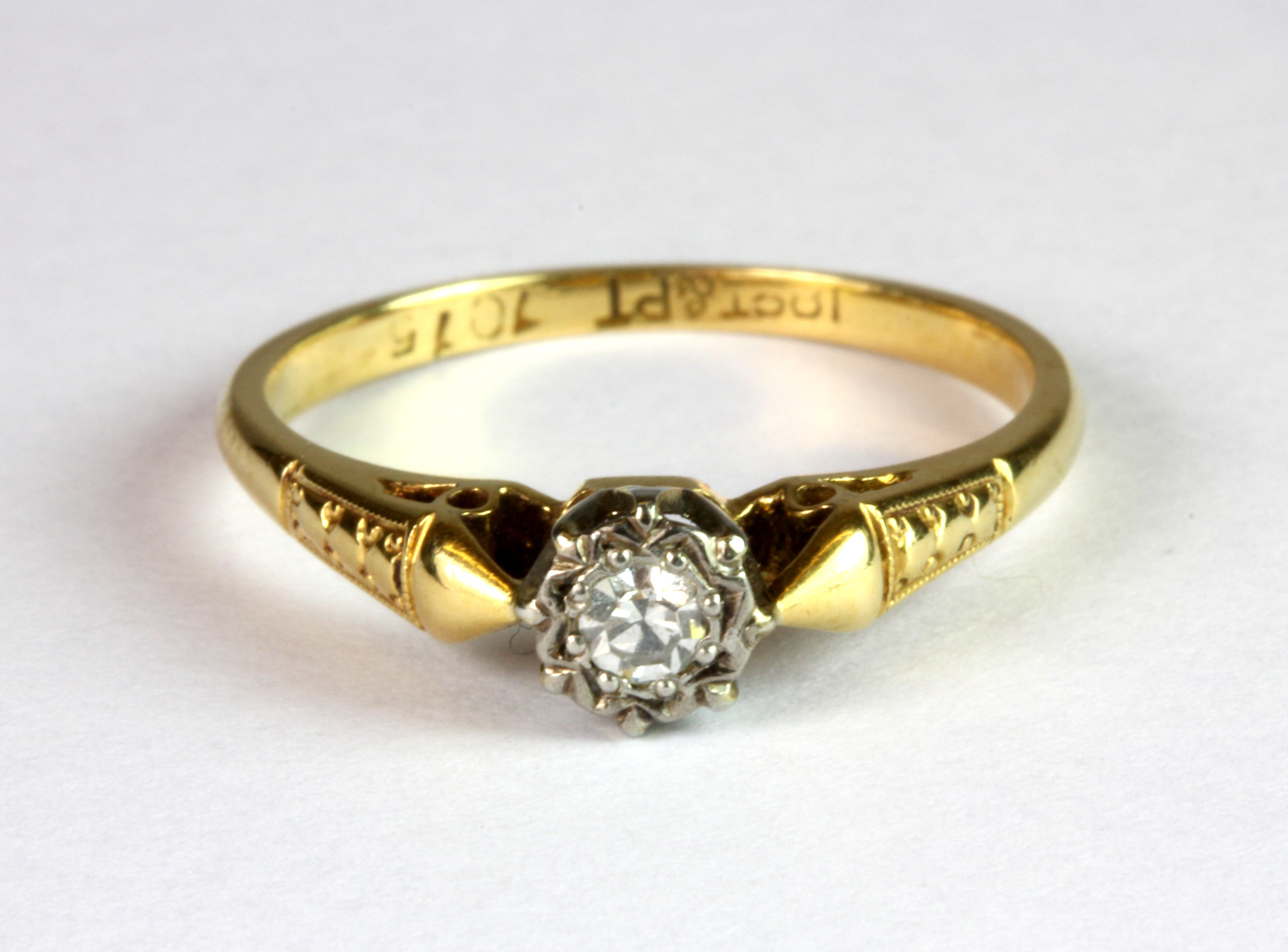 An 18ct gold and platinum (stamped 18ct & plat) diamond solitaire ring (K.5).