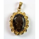 An 18ct (stamped 750) gold pendant set with an oval cut smokey quartz, L. 2.7cm.