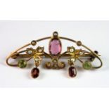 An Edwardian 9ct yellow gold bar brooch set with tourmalines, peridot and seed pearls, L. 4cm.