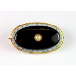 An interesting 9ct yellow gold (stamped 9ct) and enamel onyx and seed pearl set brooch, L. 3.5cm.