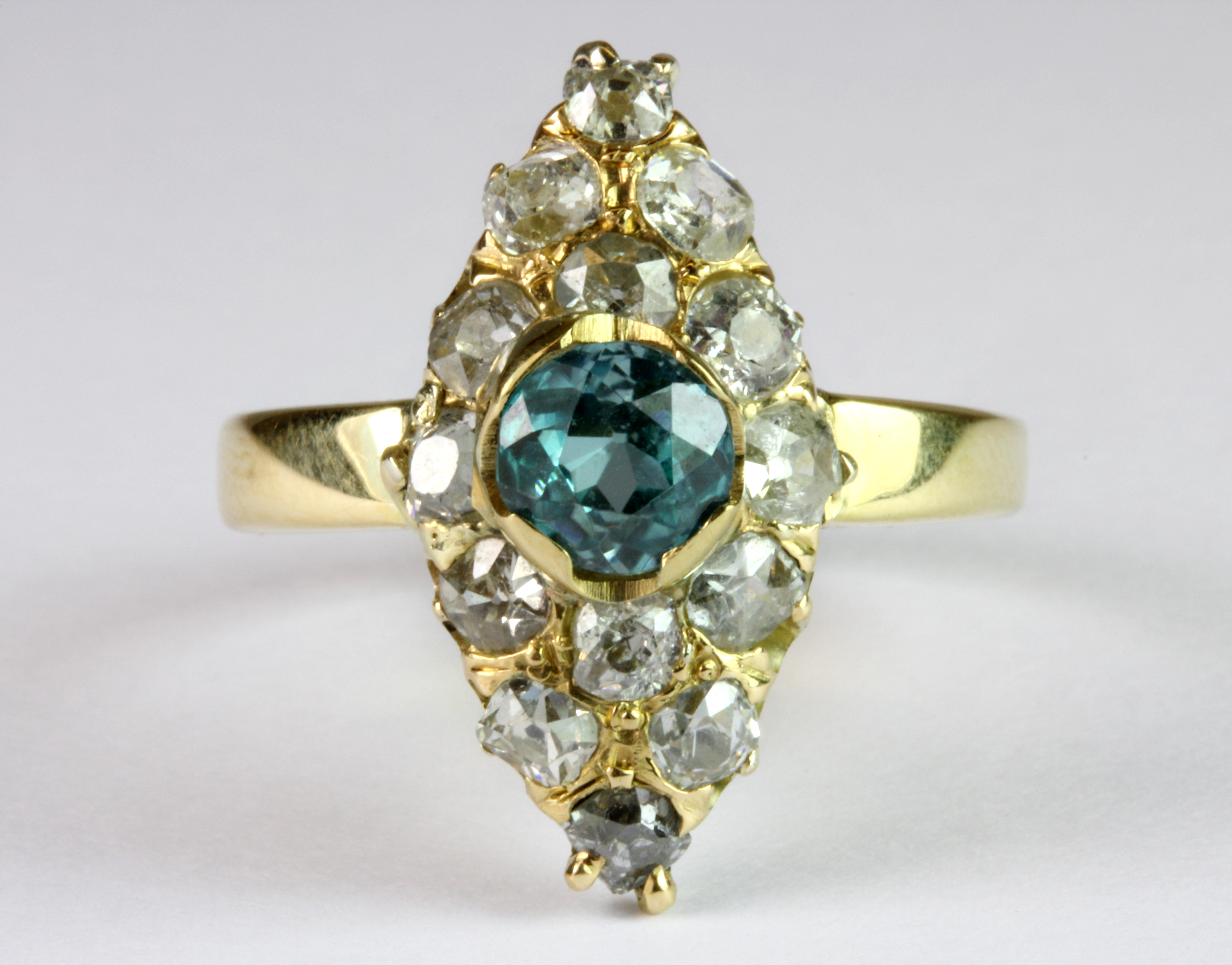 An early 18ct yellow gold (stamped 750) ring set with rose cut diamonds and a natural blue zircon (