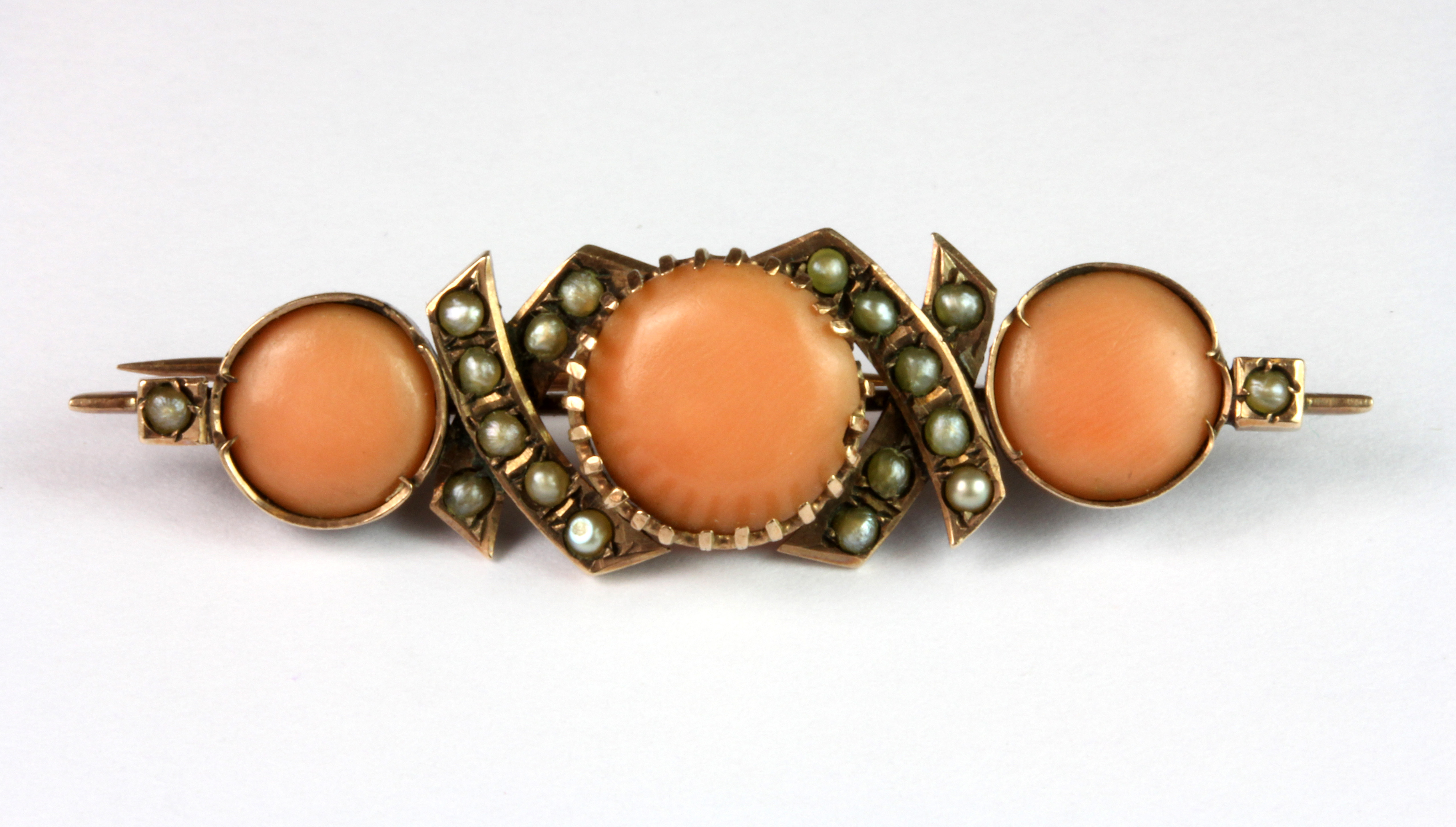 An Edwardian rose metal (tested minimum 9ct gold) coral and seed pearl set bar brooch, L. 4.5cm.