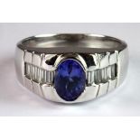 A heavy gentleman's 14ct white gold ring set with an oval cut tanzanite and baguette cut diamond set