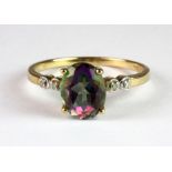 A 9ct yellow gold ring set with an oval cut rainbow topaz and diamond set shoulders (P.5).