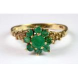 A 9ct yellow gold emerald set cluster ring (O).