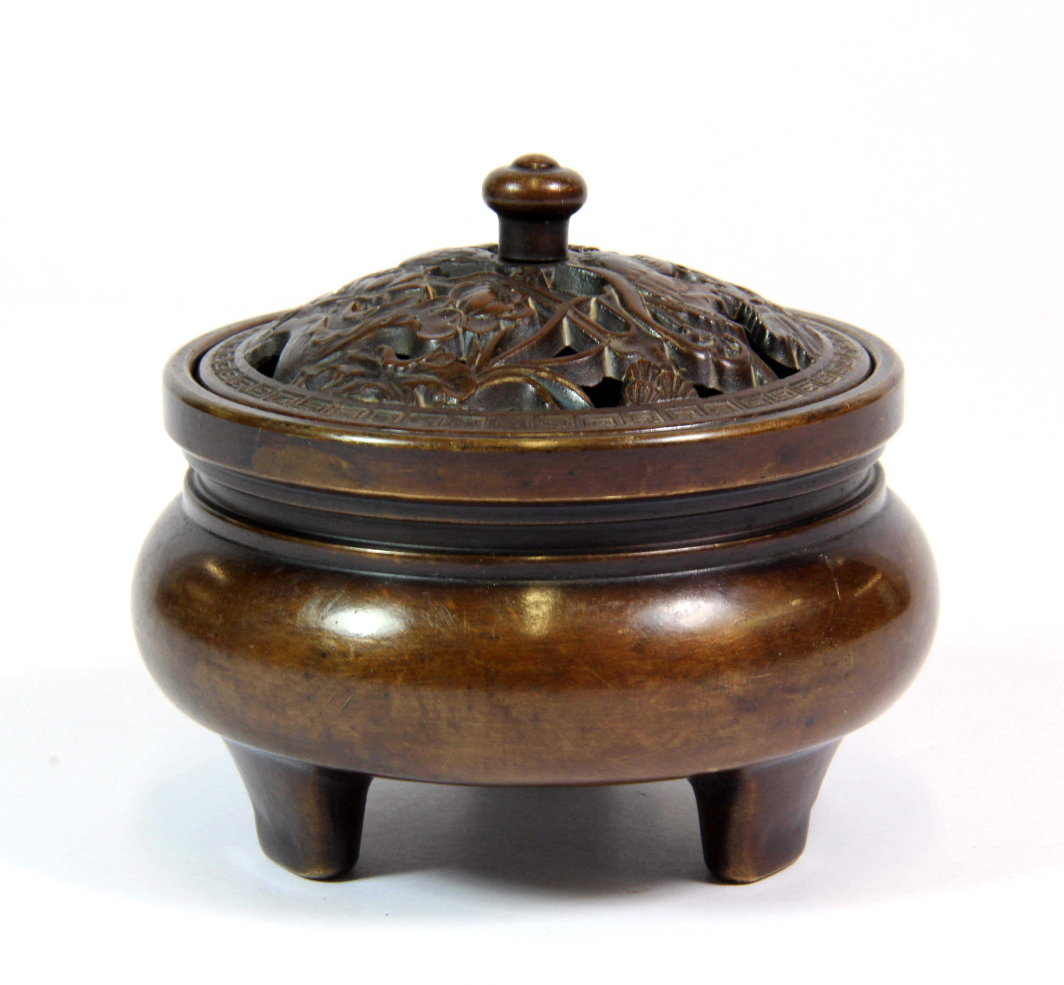 A good quality Chinese bronze censer with pierced lid depicting mandarin ducks among lotus, H. 7.