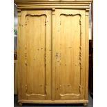 A two door ornate pine wardrobe, W. 124cm, H. 178cm.