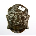 An unusual Chinese carved mixed colour jade panel depicting a man's head, pierced to be mounted on