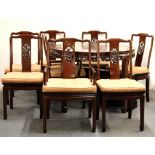 A Chinese carved hardwood extending dining table, with eight matching dining chairs.