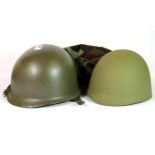 A military helmet, with liner and camouflage cover.