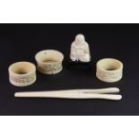 A pair late 19th century Chinese carved ivory napkin rings, together with an ivory bowl, Buddha