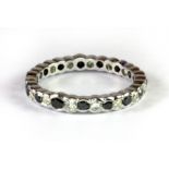 A 14ct white gold (stamped 585) white and black diamond set full eternity ring (N).
