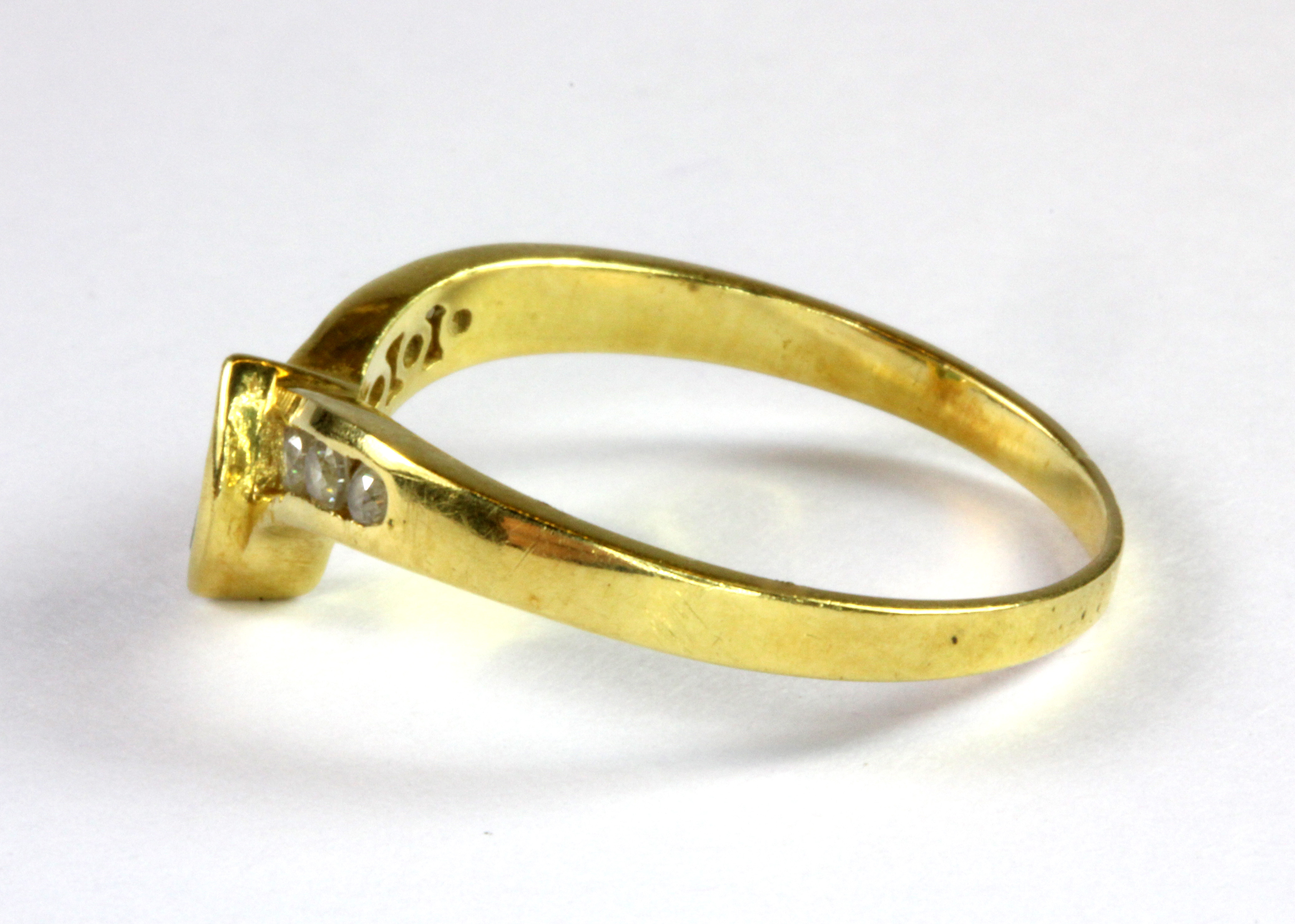 A yellow metal (tested 18ct) emerald and white stone set wishbone ring (O.5). - Image 2 of 2