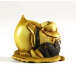 A 19th century Japanese carved and signed ivory netsuke of a figure holding a peach, L. 4.5cm, H.