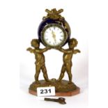 An early 20th century gilt porcelain and gilt metal cherub mantle clock, H. 19cm.