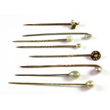 Eight antique 9ct gold pearl set antique stick pins (approx. 8.6gr overall).