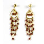 A pair of 18ct yellow gold ruby set drop earrings, L. 5cm.