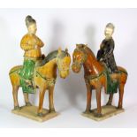 A pair of Ming dynasty style glazed pottery figures on horse back with detachable heads, H. 38cm.