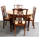 A 1920's circular mahogany ball and claw dining table and four mahogany dining chairs.