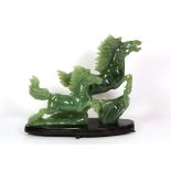 A mid 20th century Chinese carved jade / hardstone figure of a leaping horse on a wooden stand, H.