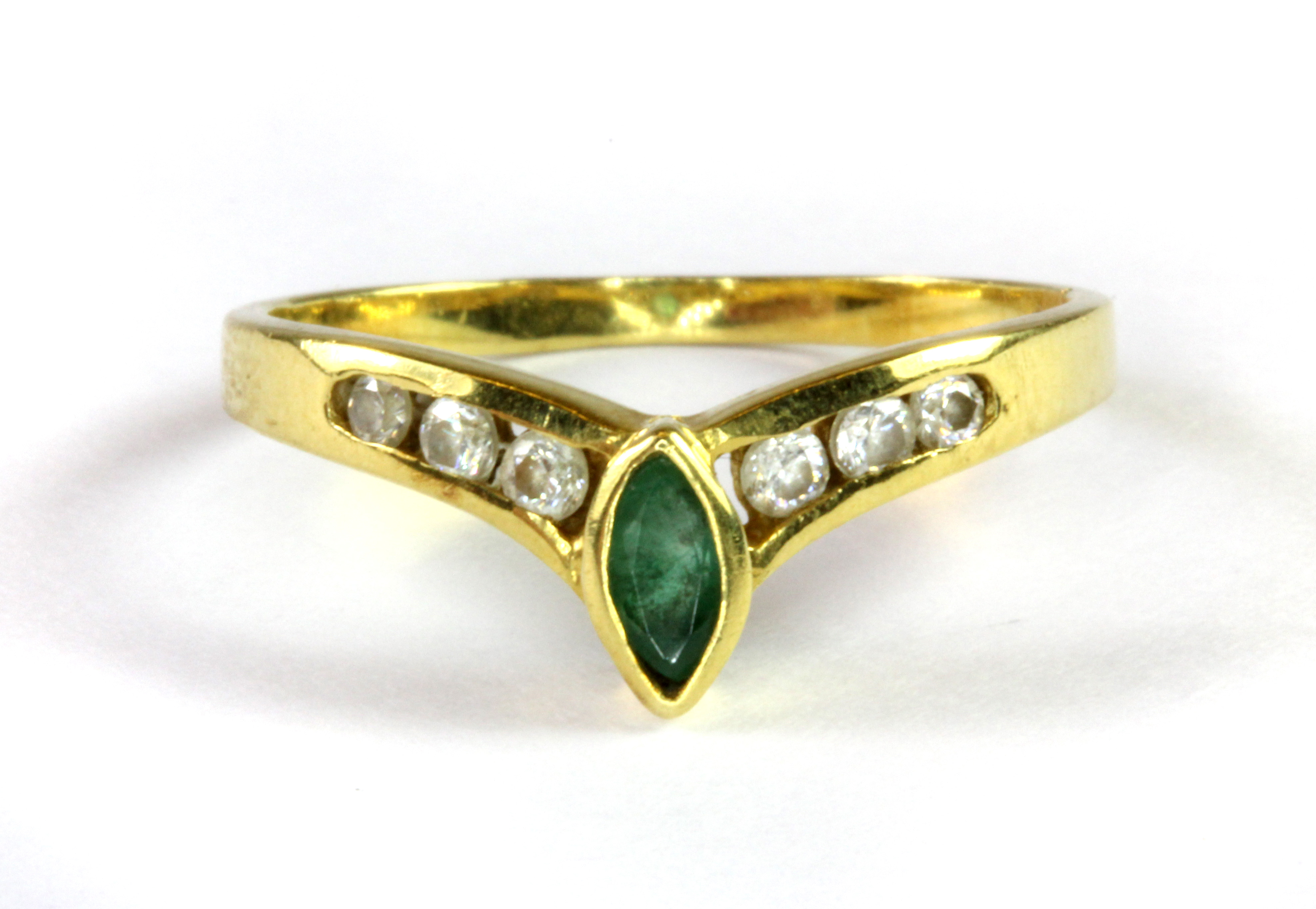 A yellow metal (tested 18ct) emerald and white stone set wishbone ring (O.5).