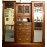 An impressive 19th century mahogany compactum with two mirrored doors, drawers and carved decorative