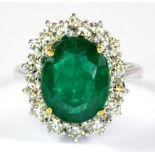 An 18ct white gold (stamped 750) ring set with an emerald (4.94ct) surrounded by diamonds (1.16ct)(