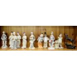 A collection of porcelain clown figures and a cold cast figure of a wolf, H. 24cm.