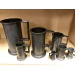 A set of 7 graduated pewter measuring jugs, each one stamped.