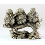 A filled silver model of three birds on a branch, H. 7.5cm.