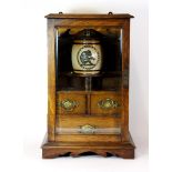 An early oak smokers cabinet with a Doulton Lambeth tobacco jar featuring a monkey smoking a pipe,